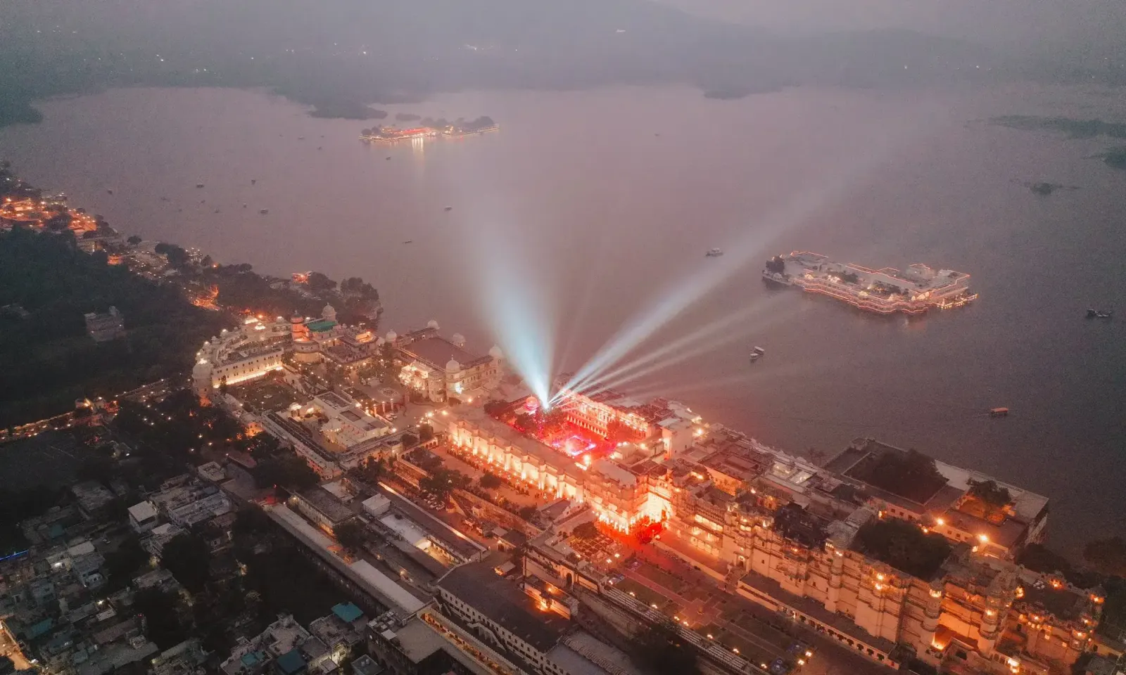 Aerial night view of a lake palace wedding venue designed by DreamzKrraft, India's most celebrated luxury wedding planners